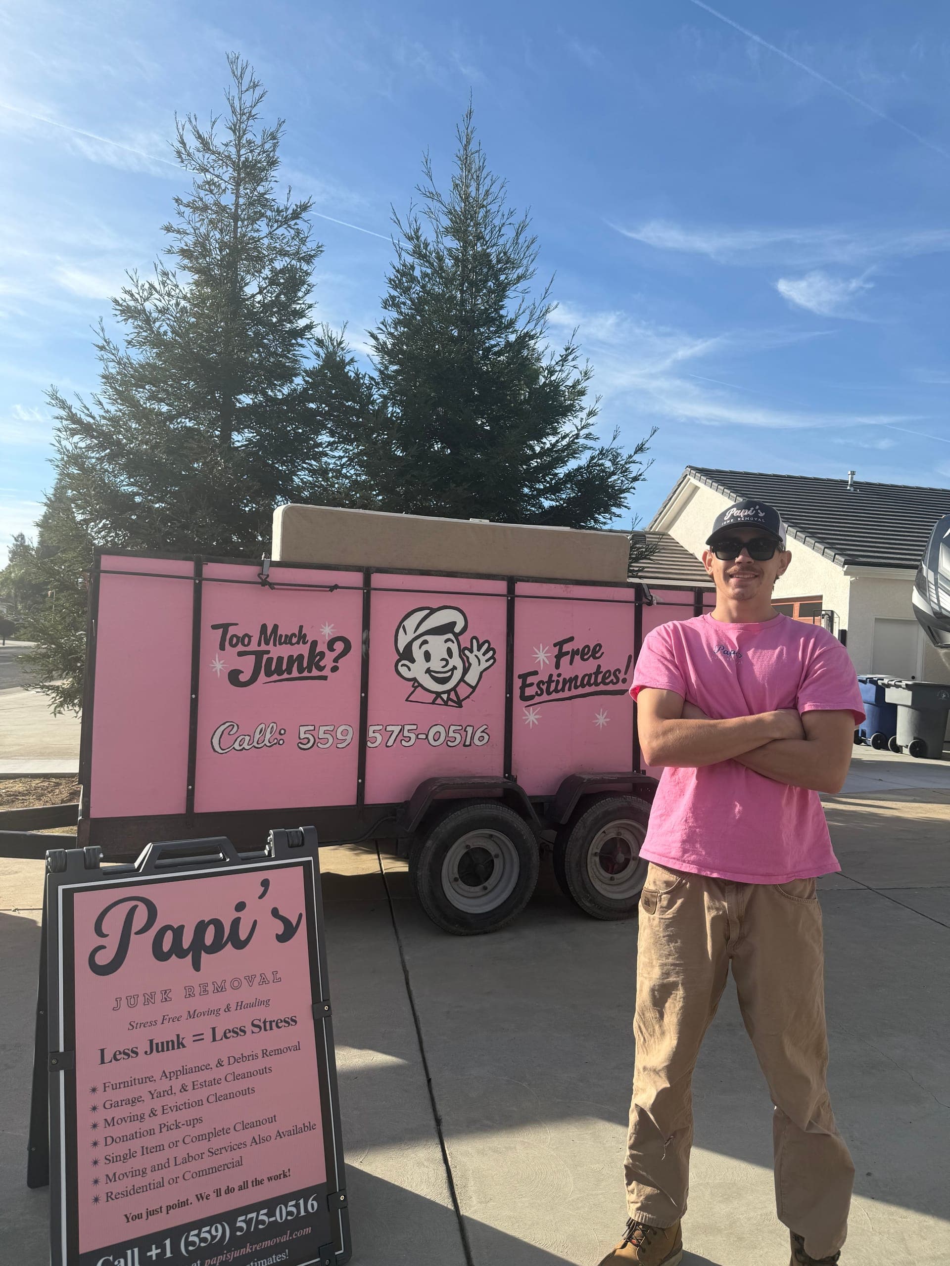 Papi's crew member in front of the pink trailer and Papi's yard sign