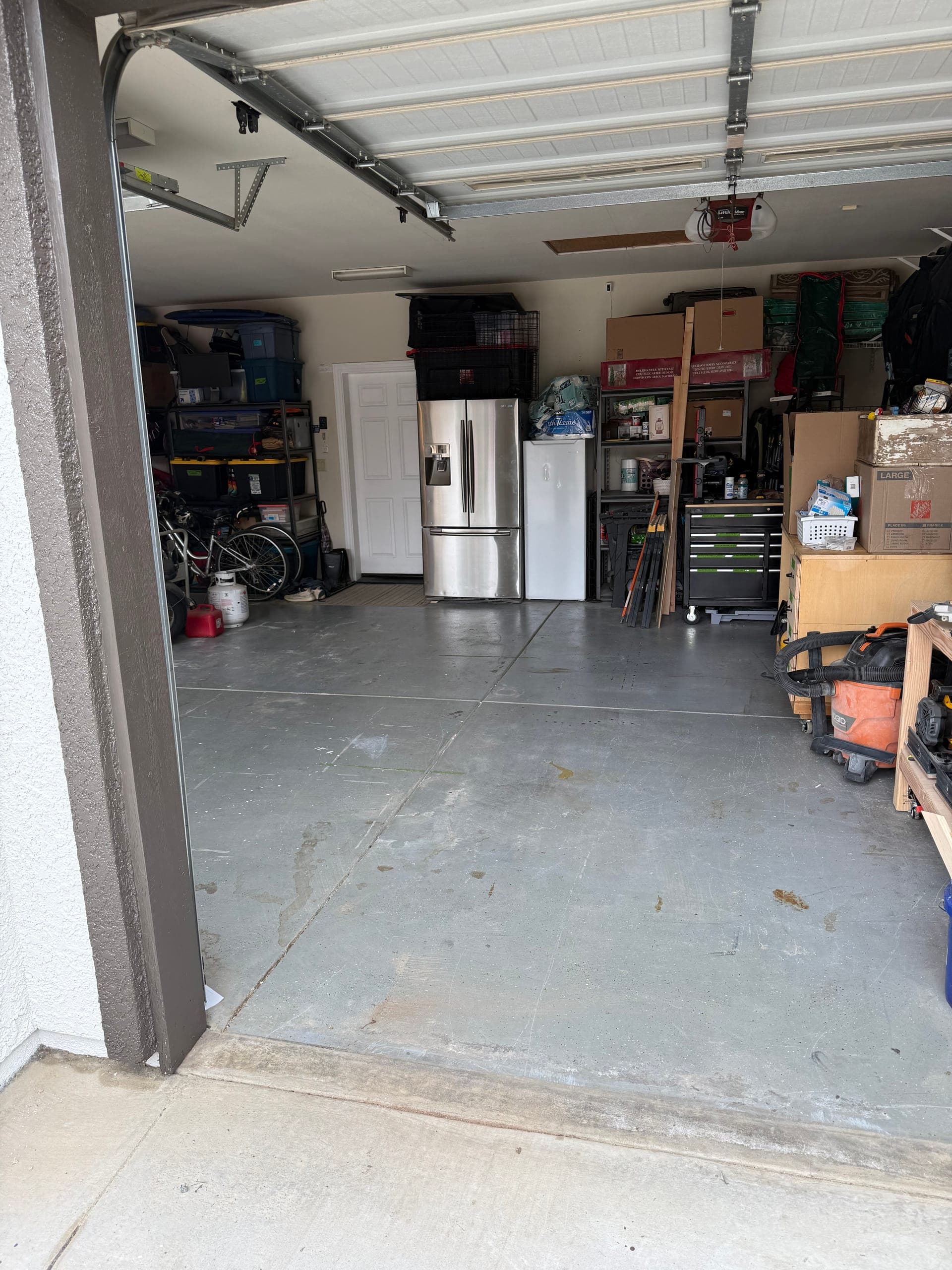 The same garage after Papi's cleanout, floor clear from the door to the fridge